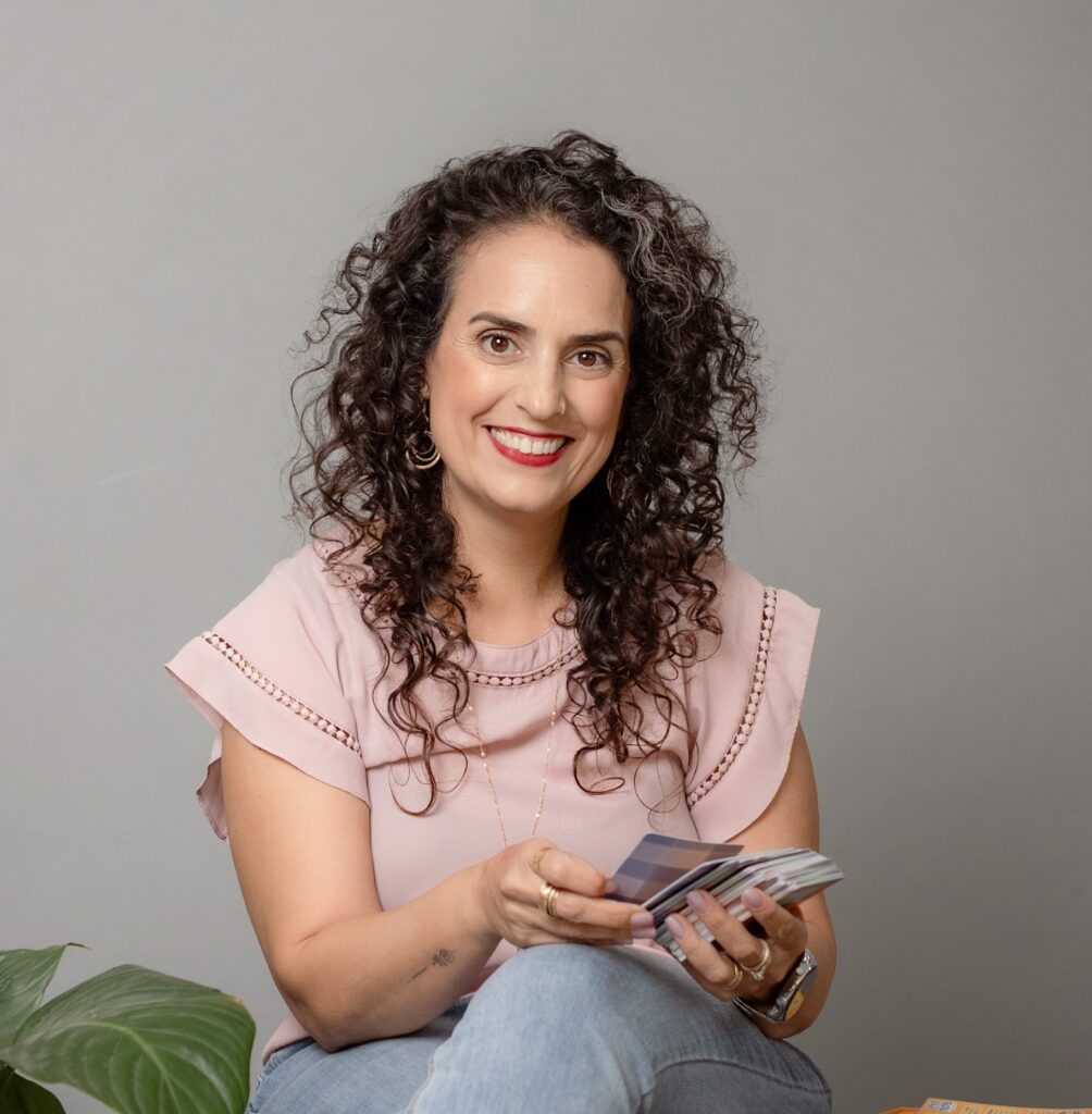 שני מחזיקה קלפים ביד בישיבה